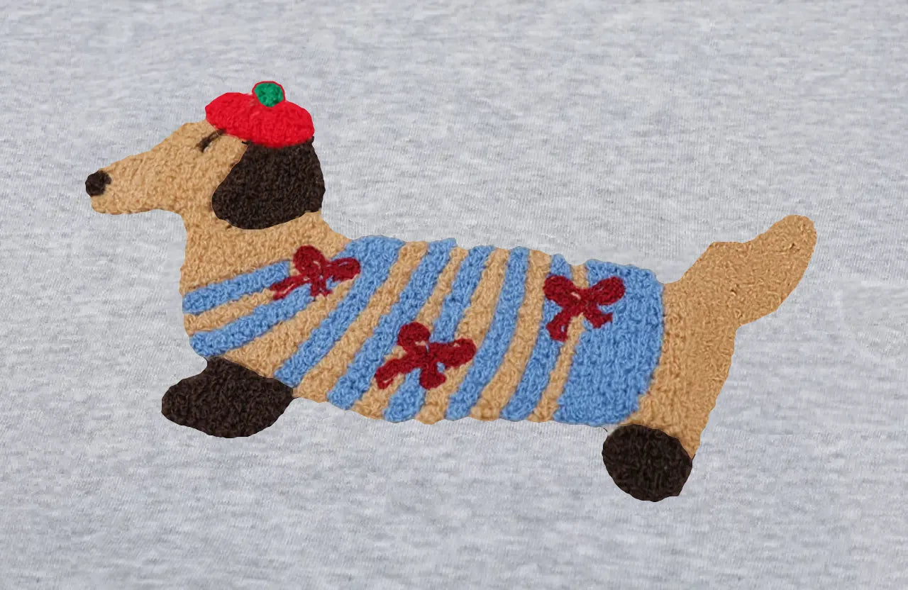 Doby: kırmızı bereli, mavi-karamel çizgili kazaklı, kulakları koyu kahverengi nakış dachshund